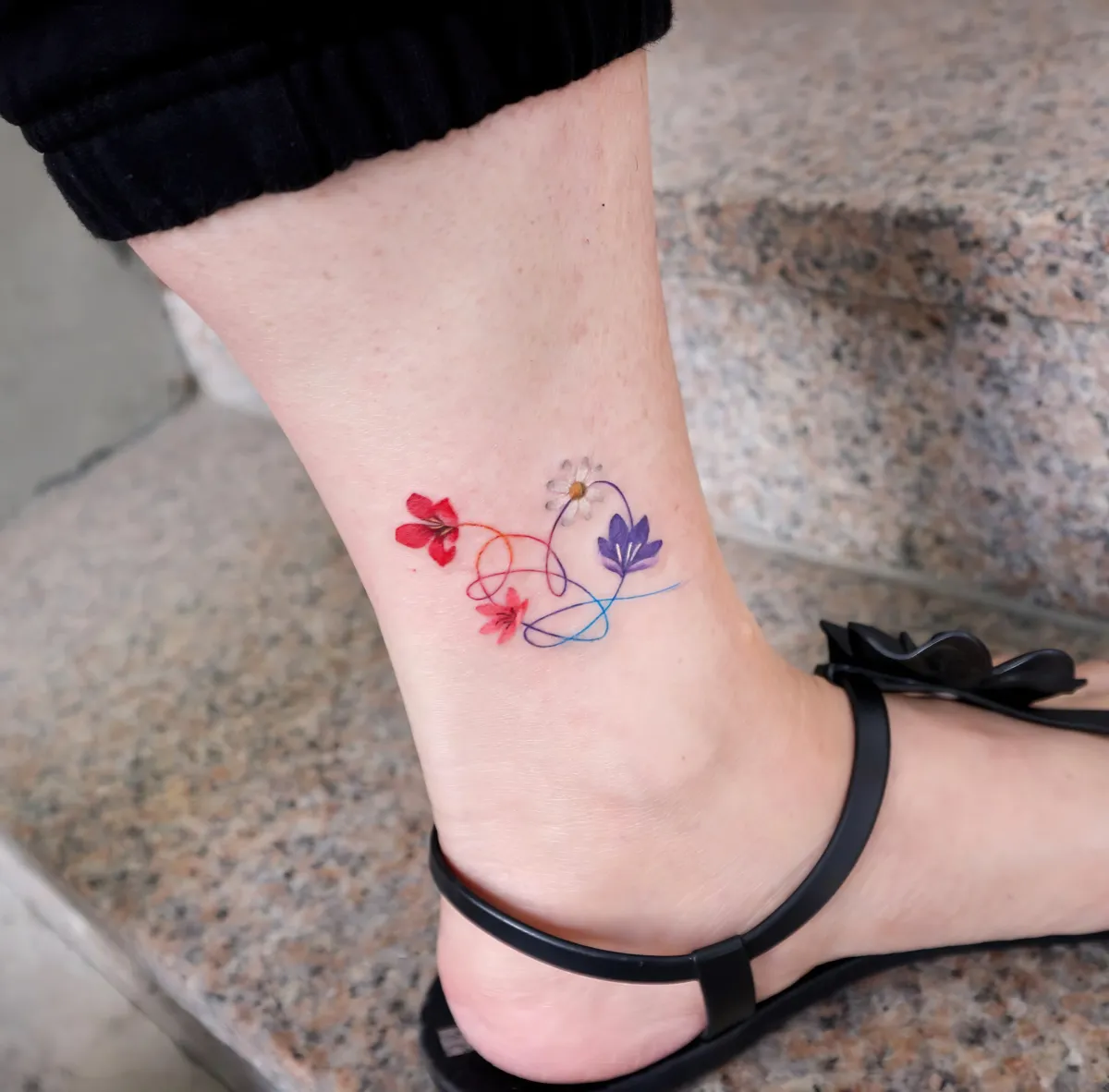 farbiges knöchel tattoo herz mit vier blumen