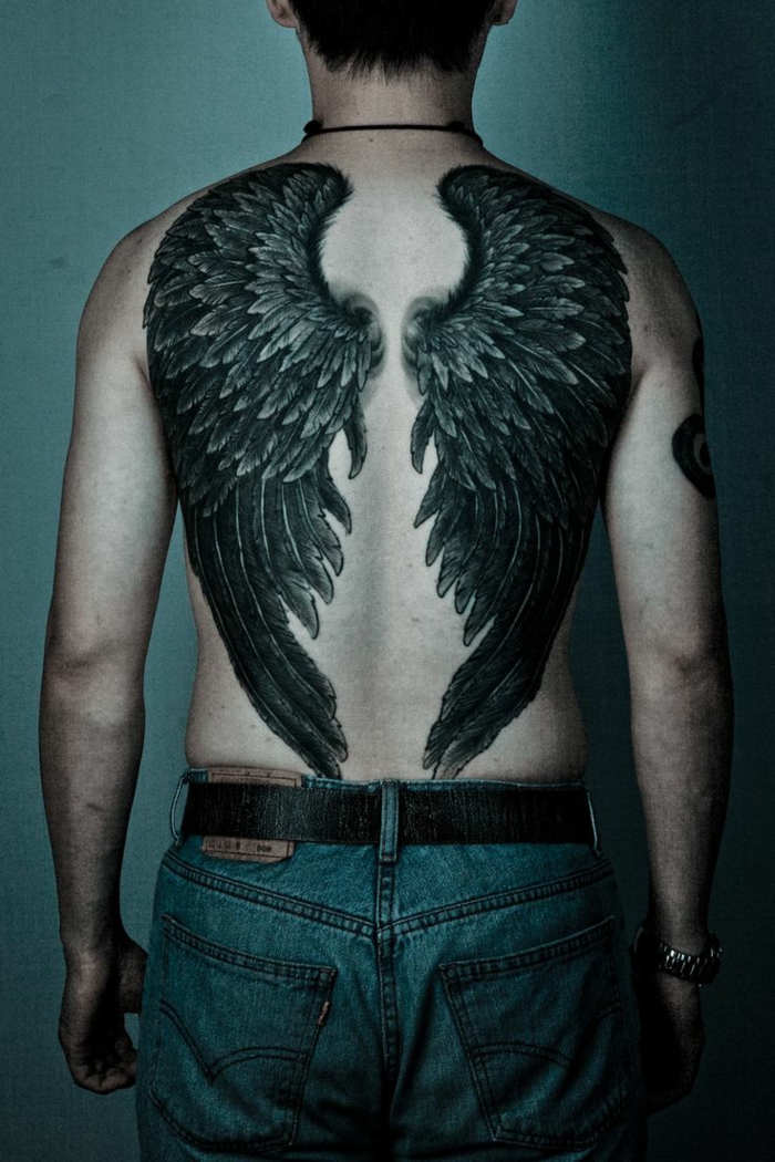 idee für schwarzen tattoo engel - hier ist ein mann mit zwei großen schwarzen engelsflügeln 