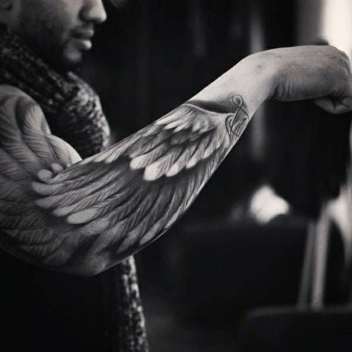 noch ein mann mit einem schön aussehenden engel tattoo mit schwarzen mit schwarzen engelsflügeln mit lagen federn 
