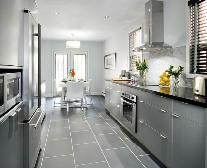 graue Küche mit grauen Fliesen am Boden, Kühschrank mit zwei Türen, Übergang zum Esszimmer