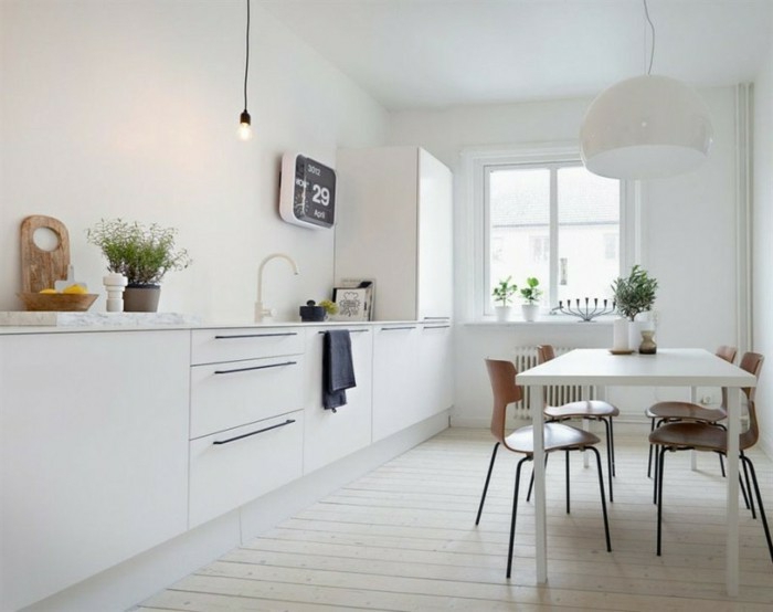 Holzboden in der Küche, elektronische Wanduhr in quadratischer Form, Kräuter, helle Küche