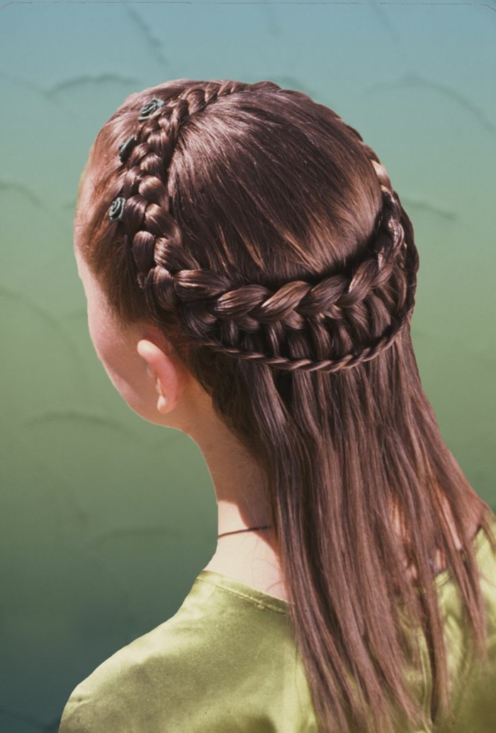 eine zarte Mädchen Frisur von Mittelalter von braunen Haar mit grünen Blumen als Haarschmuck