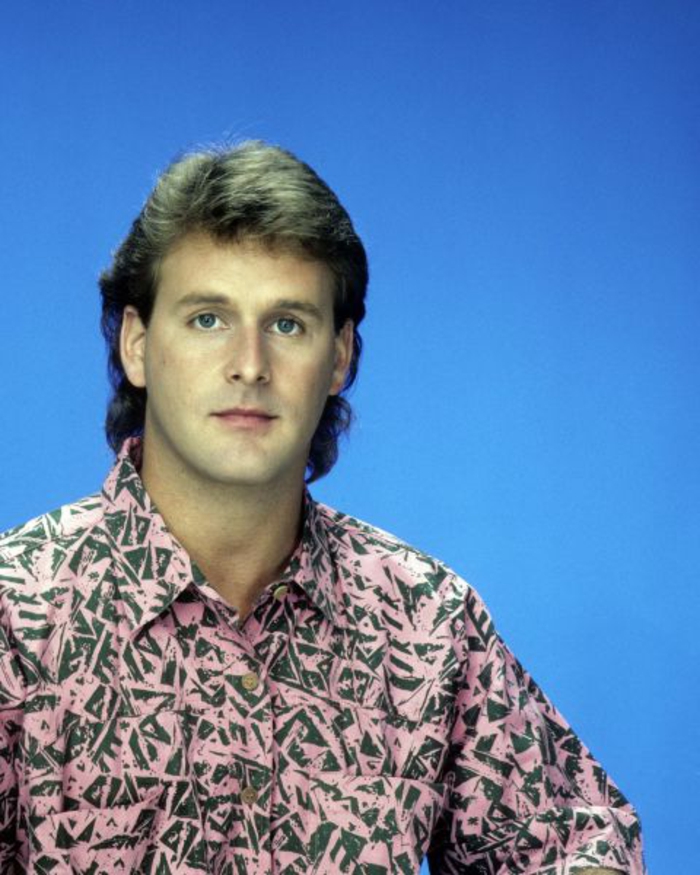 80er Mann mit pinkem Hemd mit geometrischen Figuren in grüner Farbe, 80er Frisur für Männer