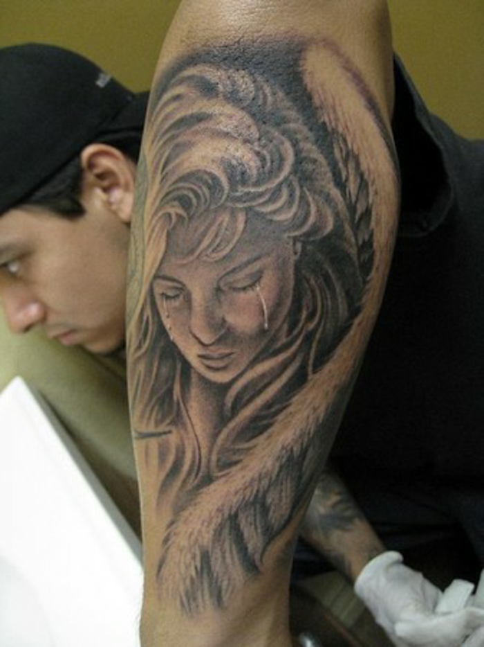eine traurige und weinende frau mit großen engelsflügeln mit weißen federn - idee für einen tattoo engel für die männer 
