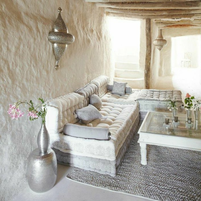 orientalische deko schlichter beduinen stil in weiß silbern metallic sessel grauer teppich blumen in vase wandlampe