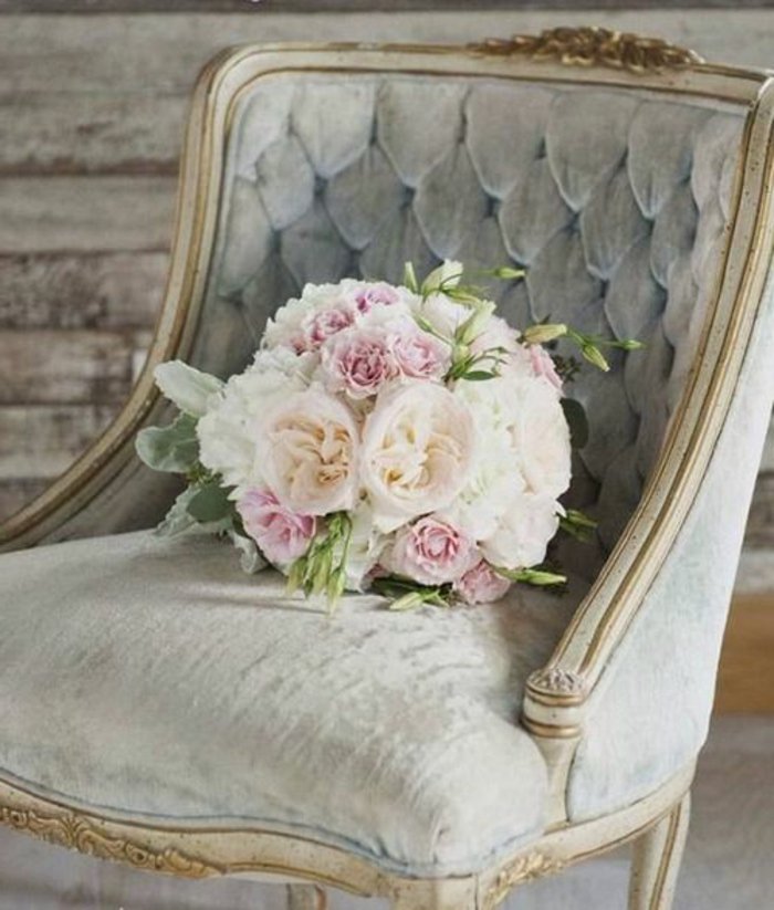 ein Blumenstrauß auf gepolstertes Sessel in perlengraue Farbe für eine Hochzeit
