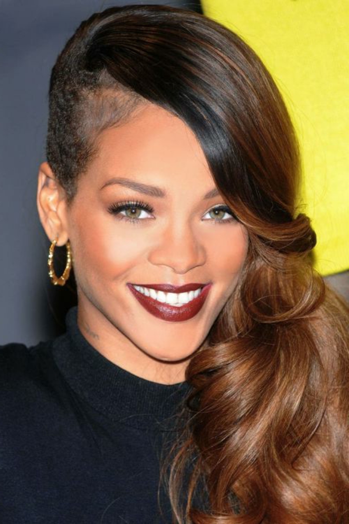 Undercut mit langen braunen Haar an einer Seite, roter Lippenstift und goldene Ohrringe Bilder von Rihanna