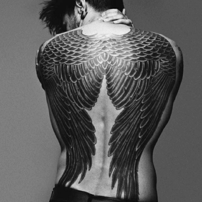ein mann mit einem tollen, märchenhaften, schwarzen engel tattoo - hier sind zwei schwarze engelsflügel mit langen schwarzen federn 