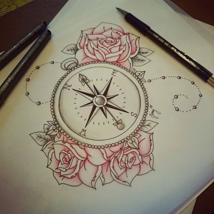 blatt papier und drei schöne pinke rosen und eine idee für einen compass tattoo 