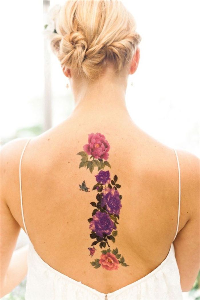 Rücken Tattoo für Frauen, Blumen-Motive in Rosa und Lila, kleiner Schmetterling