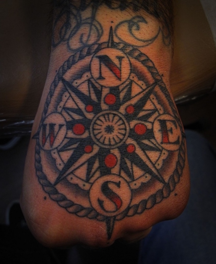 hier ist noch eine idee für einen großen schwarzen tattoo auf der hand - ein tattoo mit kompass und roten punkten