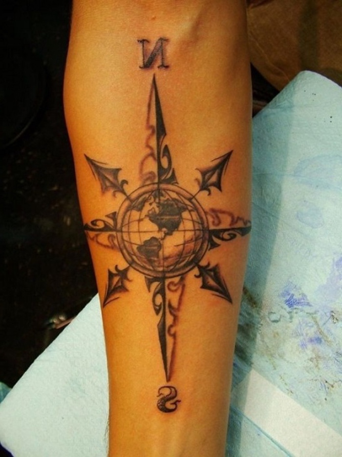 schwarzer kompass, der planet, erde - eine unserer ideen für einen compass tattoo auf der hand