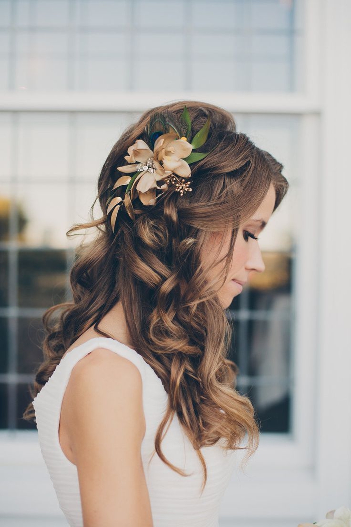 lockige Haare, eine Blume im Haar mit grünen Blätter unschuldigen Look Hochzeit Frisuren