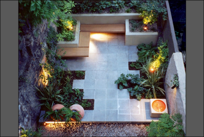 ein minimalistischer Garten mit vielen pflegeleichten Blumenbeeten, eine Sitzecke