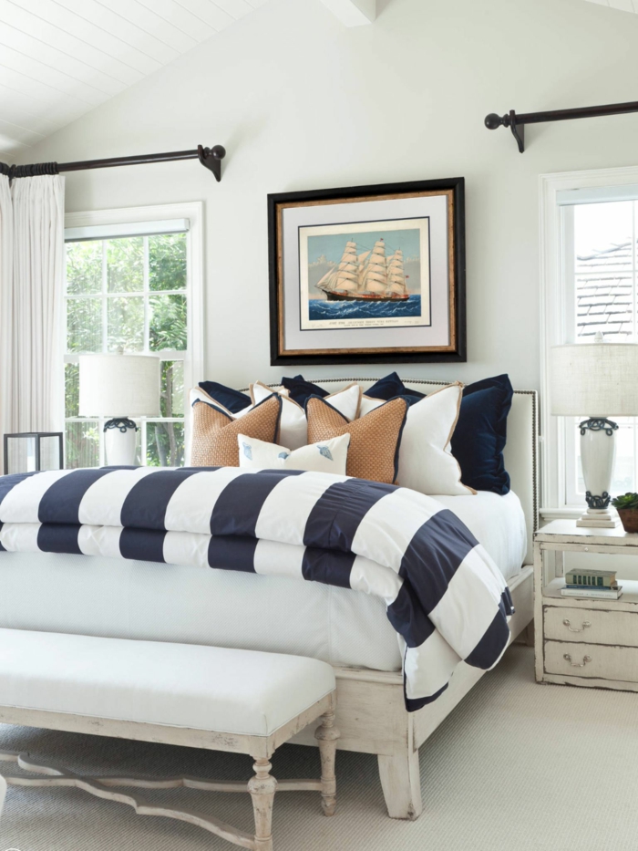 Bilde von einem Segelboot über dem Bett mit braunem Rahmen, gestreifte Bettwäsche in blau und weiß, deko maritim,