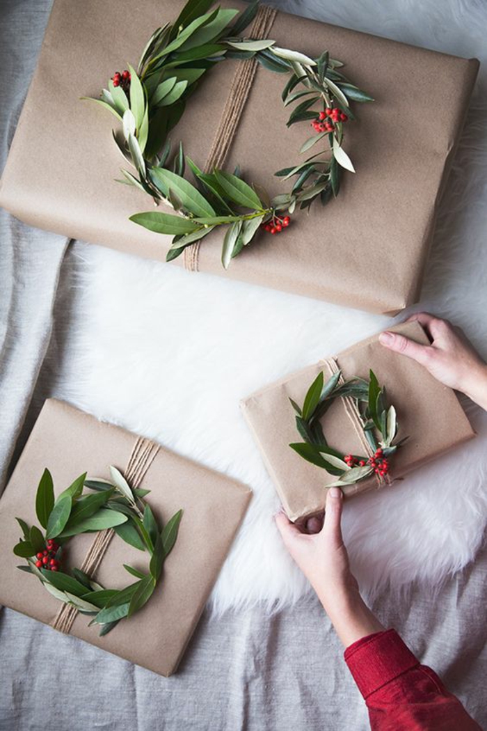 Geschenke kreativ verpacken mit grünen Kränze und rote Früchte als Dekoration