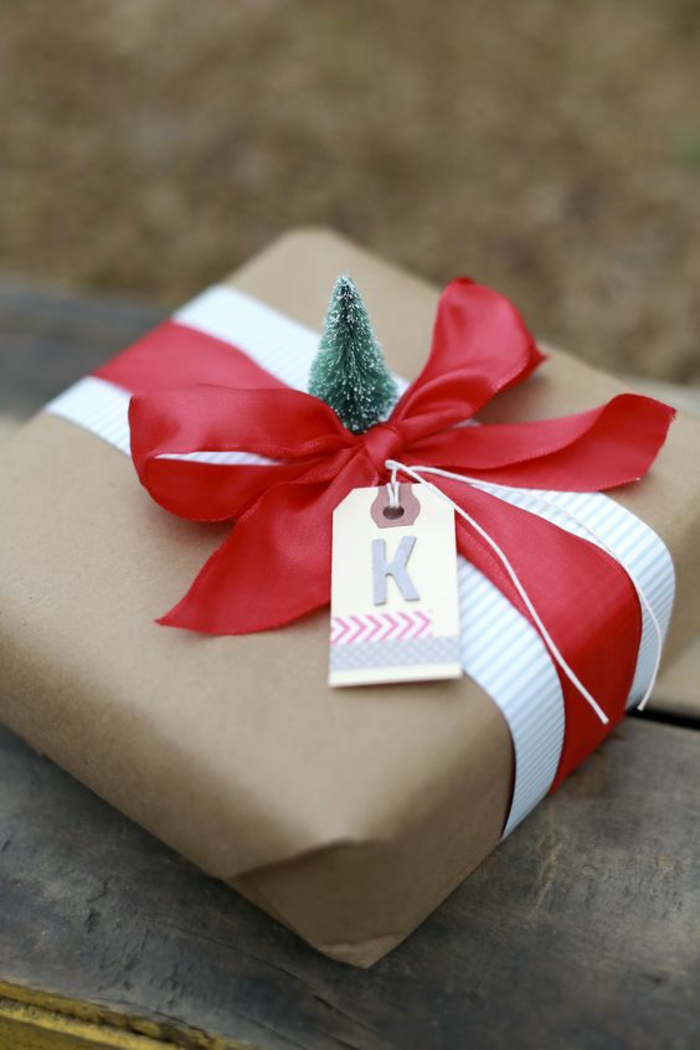Geschenke kreativ verpacken ein winziger Tannenbaum rotes Band und Karte mit dem Buchstaben