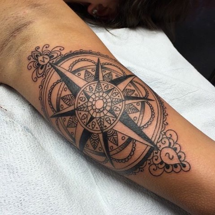 das ist eine wirklich tolle idee für einen großen schwarzen tattoo mit einem schwarzen kompass mit mandala motiven - eine tätowierung auf der hand