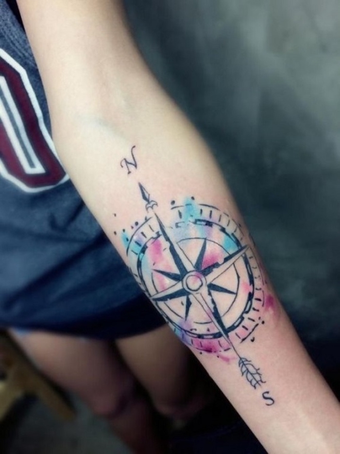 das ist eine der schönsten bunten tätowierungen mit einem großen schwarzen kompass - idee für einen compass tattoo auf der hand einer jungen frau