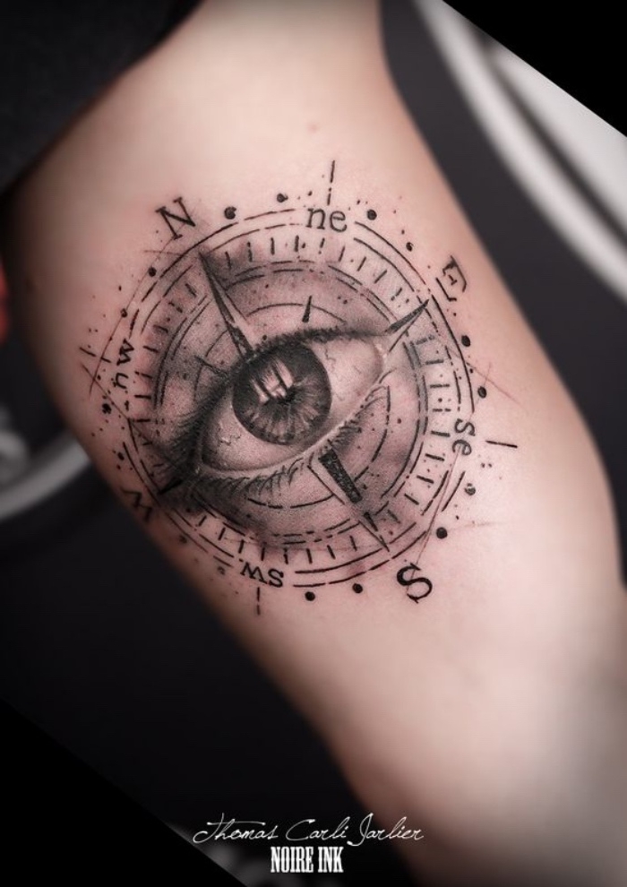 ein großes schwarzes auge und ein großes schwarzes kompass - idee für einen tollen schwarzen tattoo compass auf einer hand