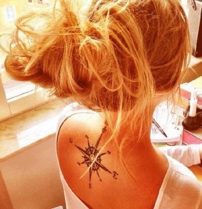 junge fra, blonde haare und ein sehr schön aussehender moderner schwarzer tattoo mit einem kompass auf den nacken