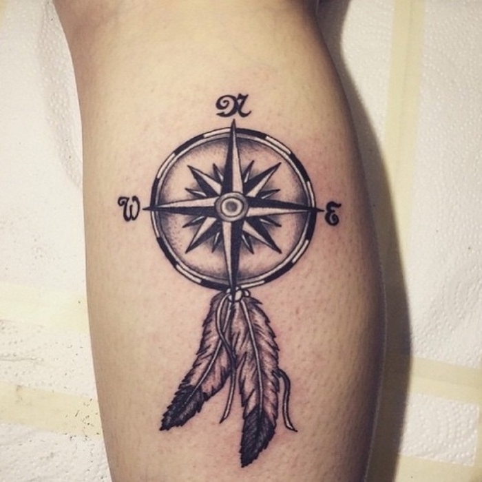 noch eine unserer zahlreichen ideen zum thema kompass tattoo mit zwei langen weißen federn auf der hand