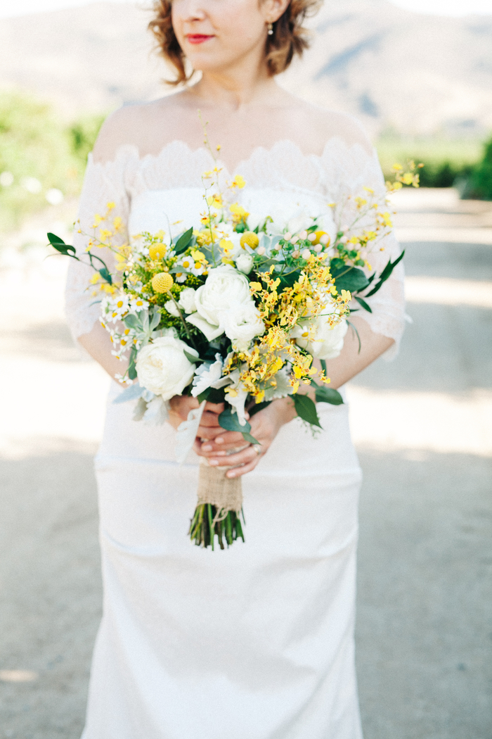 schöne weiße Hochzeitskleid, gelbe Blumen und weiße Rosen in vintage Brautstrauß