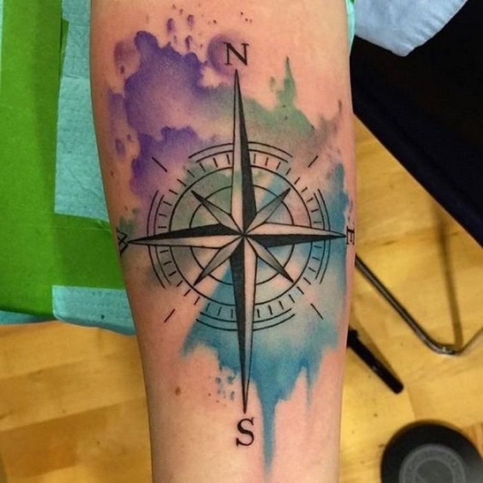 ein schöner schwarzer großer tattoo mit einem schwarzen kompass - eine hand mit einem compass tattoo und bunten farben