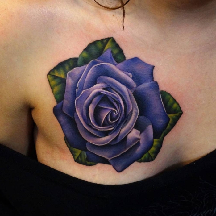 eine tolle kleine lila rosen tätowierung mit grünen blättern - idee für ein tattoo für frauen 