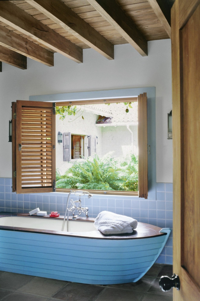 Einrichtung Maritime Badezimmer, Badewanne wie ein Segelboot in hellblau, blaue Fliesen, Holzdach und Holzfenster