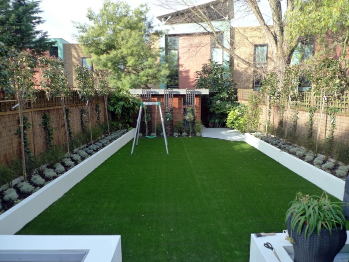 zwei symmetrische Reihen von Pflanzen an dem Zaun, grüner Rasen - moderner Vorgarten