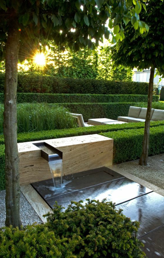 ein Wasserspiel auf dem Hintergrund steht der Sonnenuntergang - moderner Vorgarten