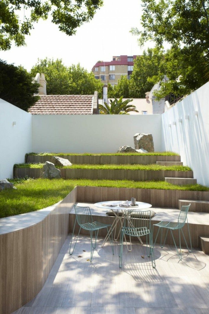 ein Garten auf Stufen mit Rasen, schlichte Gartenmöbel - Gartengestaltung Beispiele