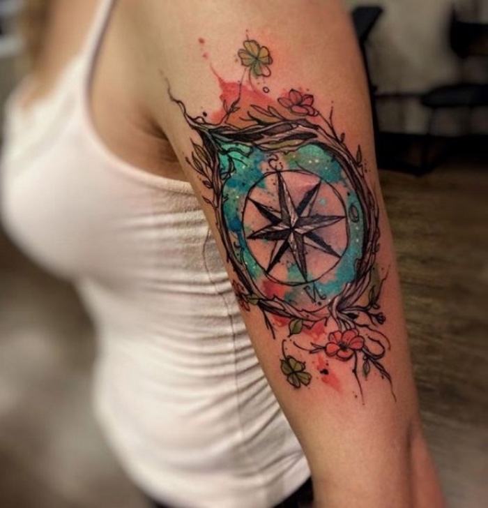 das ist eine idee für einen compass tattoo für frauen - ein kompass und kleine grüne und rote blumen