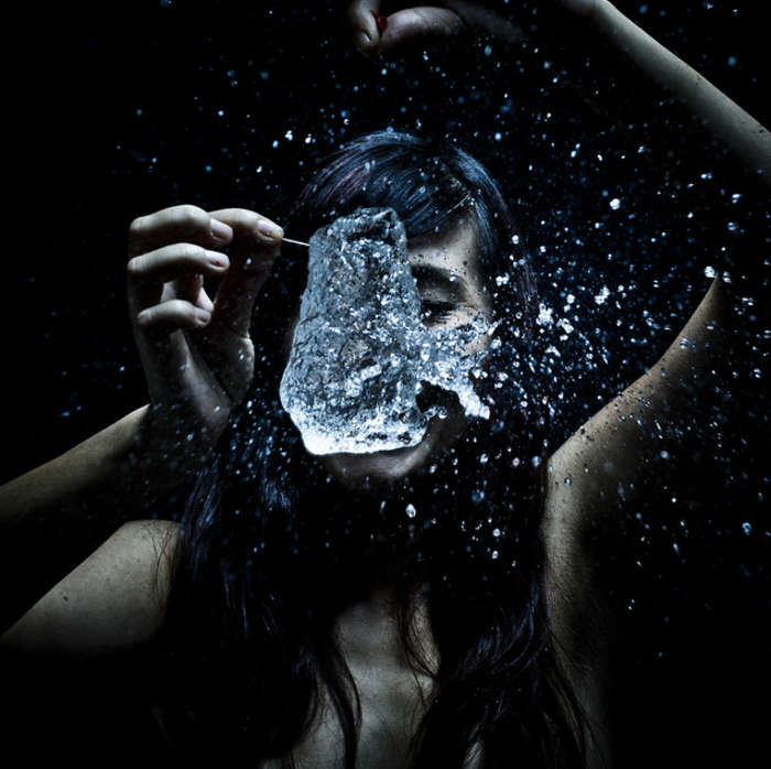 Innere Kraft, Kreativität und Energie, Frau mit Wasser spielen, dunkler Hintergrund 