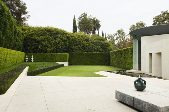 ein bildschönes minimalistisches Design von Vorgarten mit hohen Hecke