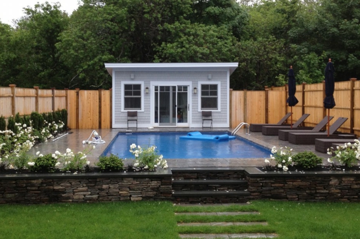 ein winziger Haus mit einem enormen Schwimmbad vorn - moderner Vorgarten