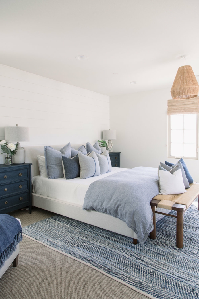 kleine blaue Kommode, Schlafzimmereinrichtung im maritimen Stil, maritime Farben, blaue Bettwäsche und Teppich