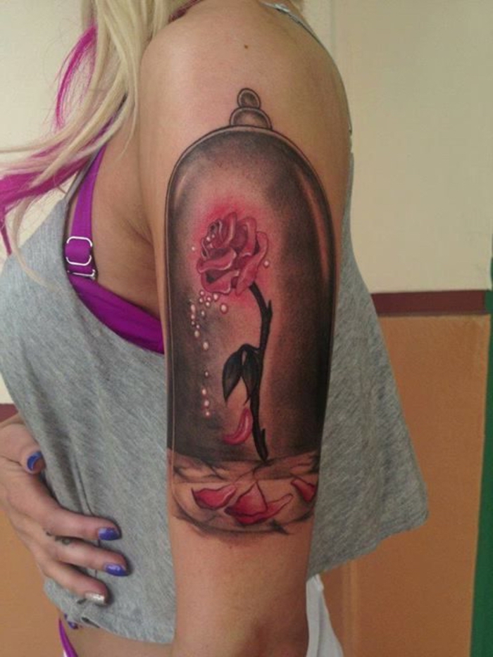 idee für einen pinken tattoo auf der hand - eine pinke rose mit märchenhaften motiven - die schöne und das biest - eine frau mit rosen tattoo