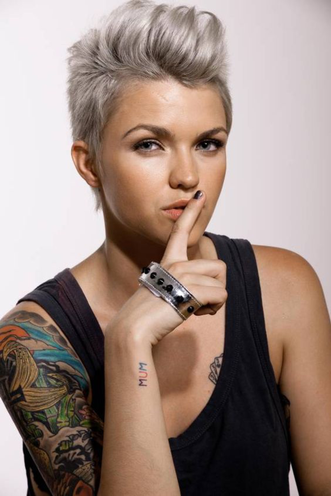 eine rebellische Frau mit grauem Haar Kurzhaar Undercut und bunte Tattoos