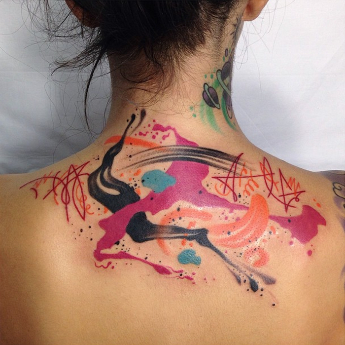 ein bunter Wasserfarben Tattoo mit abstrakte Muster wie Flecken in rosa und oranger Farbe