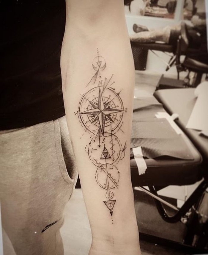das ist eine idee für einen compass tattoo mit einem schwarzen kompass mit langen großen schwarzen pfeilen 