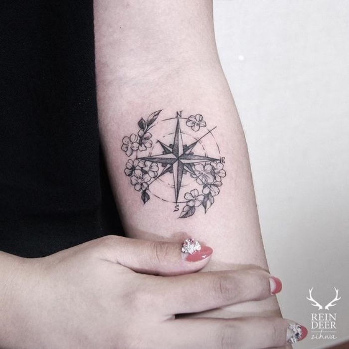 ein schwarzer kompass mit kleinen weißen blumen - idee -für einen compass tattoo