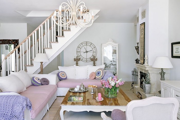 wohnzimmer im shabby chic-stil, sofas in weiß und lila mit bunten dekokissen, kaffeetisch aus holz