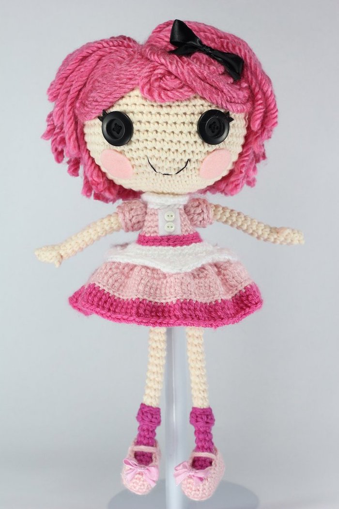 Amigurumi häkeln - eine rosa Puppe mit schwarzen Knopfaugen und rosa Wangen