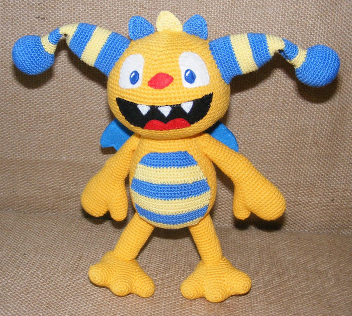 seltsames Geschöpf in gelber und blauer Farbe mit geöffnetem Mund - Glücksbringer häkeln
