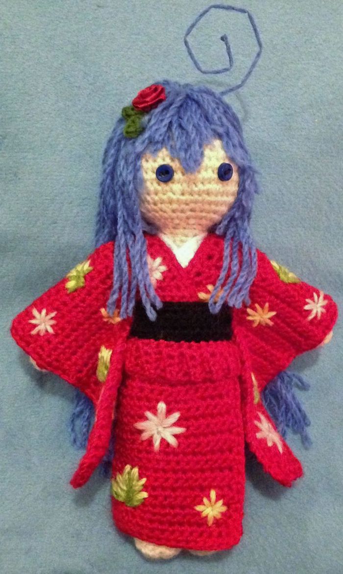 eine japanische Puppe aus anime, lila Haar und rotes Kleid mit einer Rose
