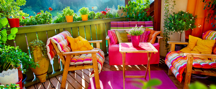 gemütliche und frische Atmosphäre auf dem Balkon, Möbel in grellen Farben und viele Blumentöpfe