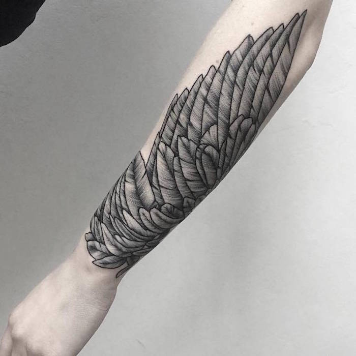 Tattoo realistic ein Flügel in schwarzer Farbe am ganzen Arm Kontrast mit der blassen Haut