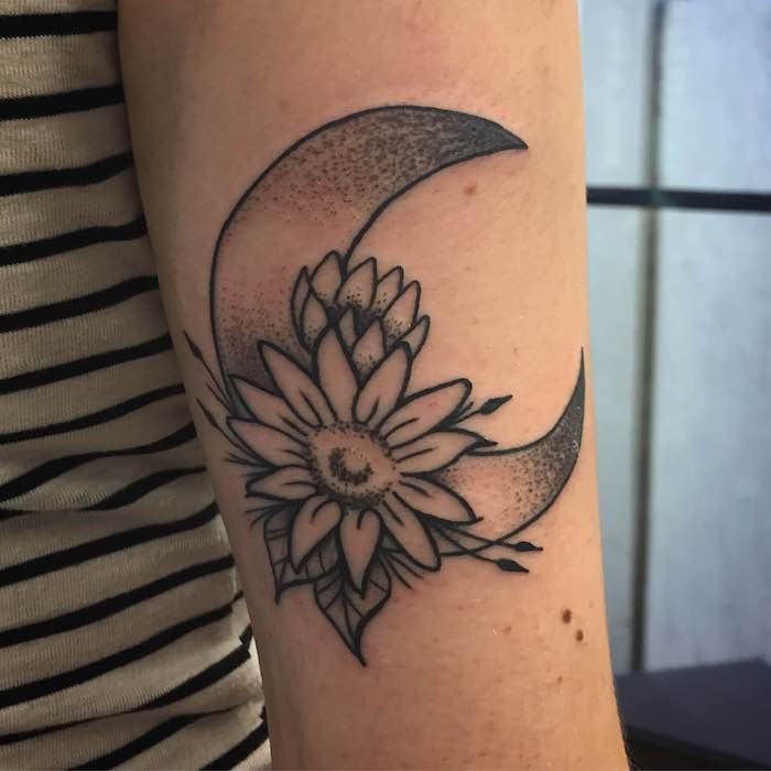 ein niedliches Tattoo mit einer Blume und dem Mond Tattoo Arten am Oberarm